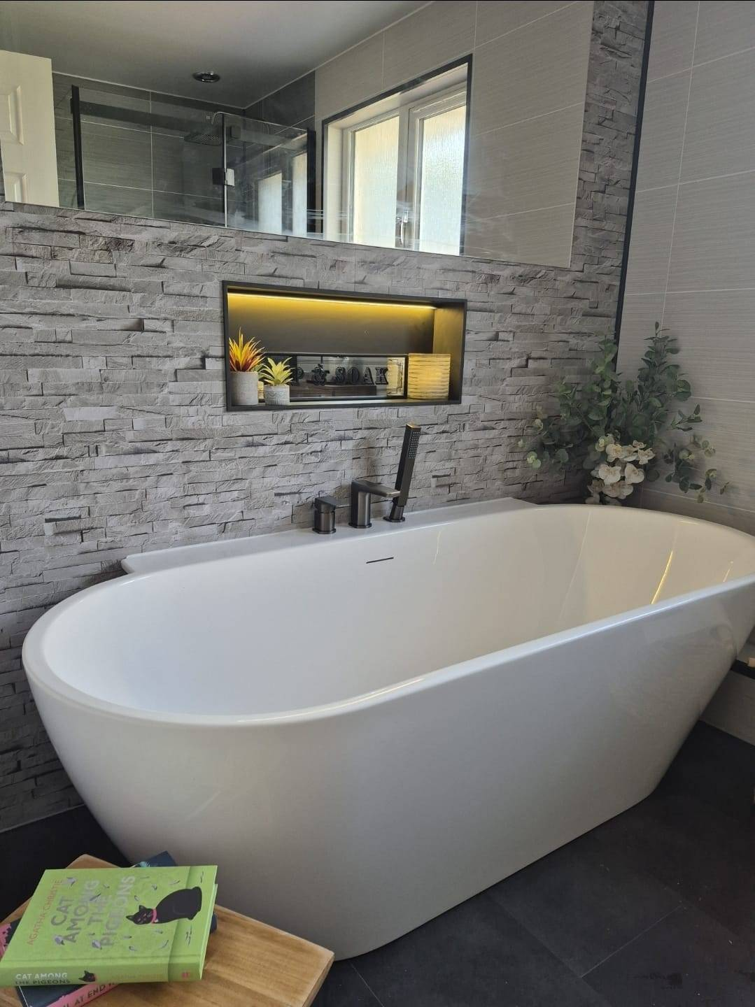 Luxury bathroom renovation by On Demand Plumbing — freestanding bath with feature stone wall